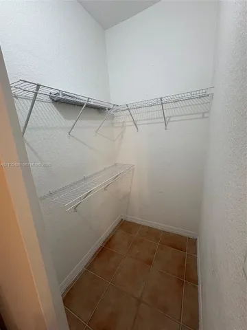 Built-in wire shelving, tiled flooring, and neutral wall finishes
