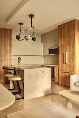 Kitchen with wood-finish cabinetry, integrated refrigerator, and built-in microwave