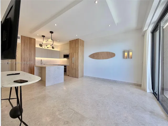 Open-concept living space with light-toned flooring, recessed lighting, and a modern kitchen