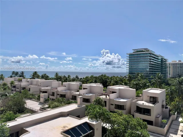 Modern low-rise buildings with multiple balconies, surrounded by lush tropical landscaping