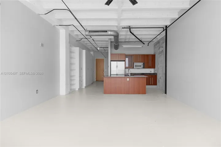 Open-concept living area with concrete flooring, exposed ceiling beams, and industrial-style ductwork