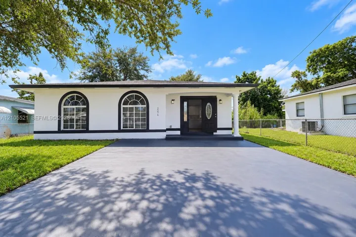 White exterior with black trim, arched windows, and a covered entry
