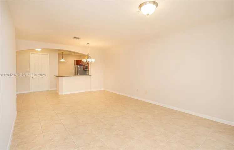 Tiled flooring throughout, an arched entryway, and a breakfast bar with a stone countertop