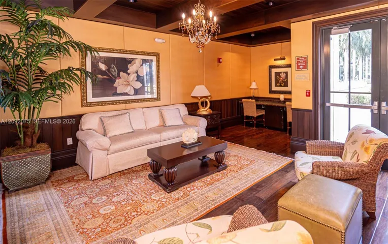 Wood-finish flooring, dark wood wainscoting, and a chandelier with decorative accents
