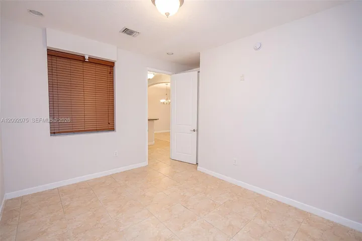 Recessed lighting, ceiling-mounted light fixture, tile flooring, interior door, window with wood-finish blinds
