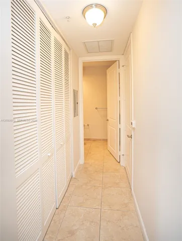 Recessed ceiling light fixture, louvered bi-fold closet doors, tile flooring, and white interior doors