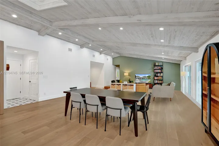 Vaulted wood-finish ceilings with recessed lighting, light wood-finish flooring, white walls, and a green accent wall