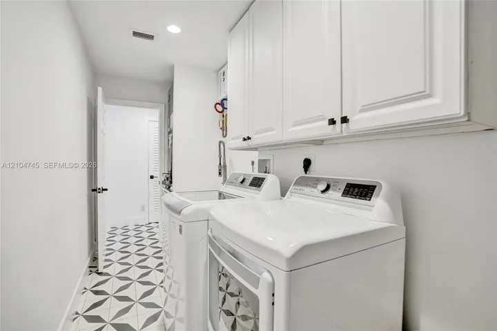 White shaker cabinetry, recessed lighting, and patterned floor tiling