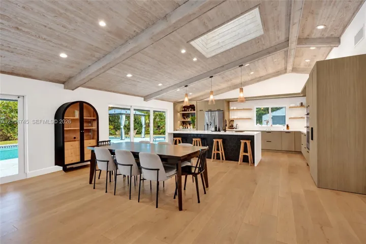 Vaulted wood-finish ceiling with exposed beams and recessed lighting