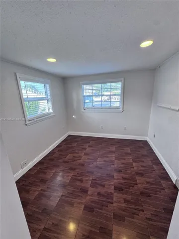Wood-finish flooring, recessed lighting, and two windows with blinds