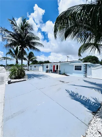 Light blue exterior siding with a red entry door, white framed windows, and a white fence