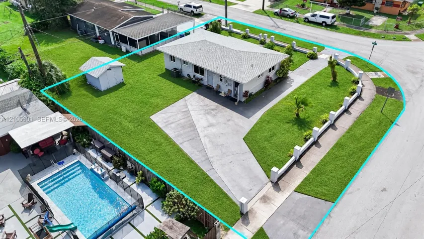 Single-story residence with a concrete driveway, a front lawn with landscaping, and a fenced backyard featuring a swimming pool