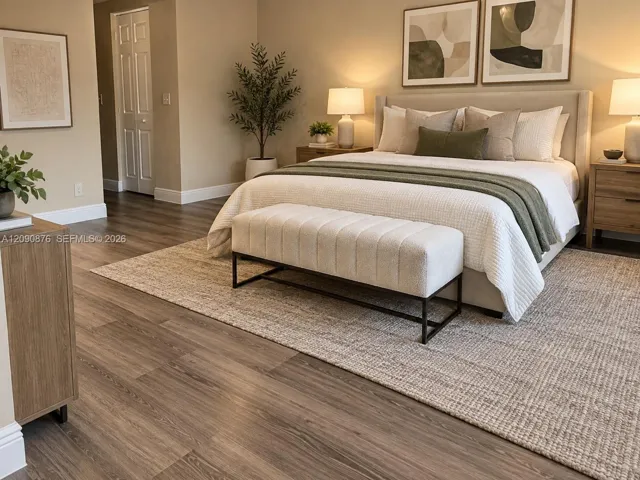 Wood-finish flooring throughout, featuring a neutral color palette and a prominent upholstered bed frame