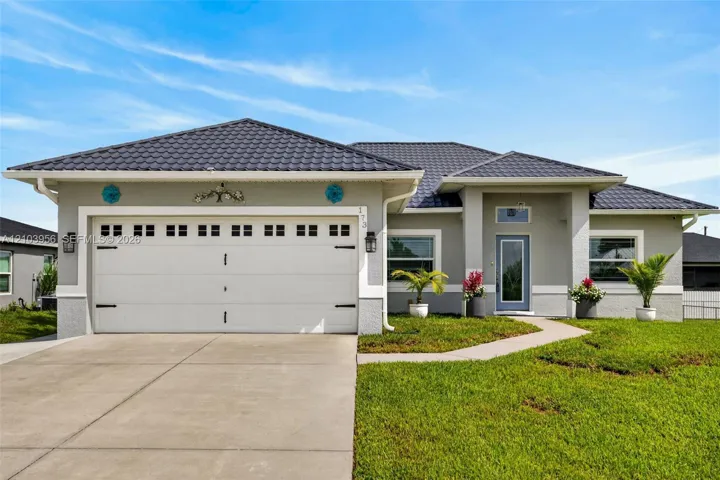 Single-story residence featuring a tile roof, light gray exterior, and an attached two-car garage