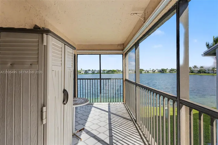 Screen-enclosed porch featuring tiled flooring, a metal railing, and direct water exposure