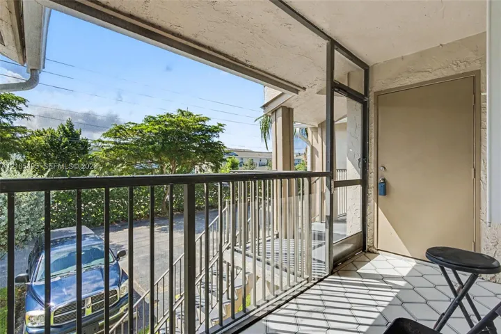Covered balcony featuring hexagonal tile flooring, metal railings, and a screen enclosure