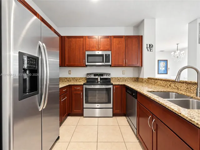 Kitchen featuring shaker-style wood cabinetry, stone countertops, stainless steel appliances, dual-basin sink, and tile flooring