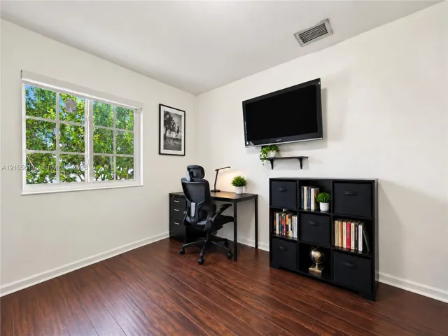 Room featuring wood-finish flooring, white walls, and a multi-pane window