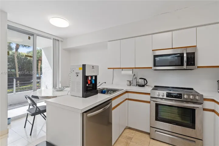 Functional kitchen featuring a convenient breakfast area and direct balcony access, offering a comfortable setting for everyday dining at Mystic Pointe in Aventura.