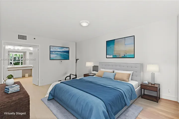 Expansive primary bedroom featuring beautiful water views and a private en-suite bathroom, offering comfort and tranquility at Mystic Pointe in Aventura.