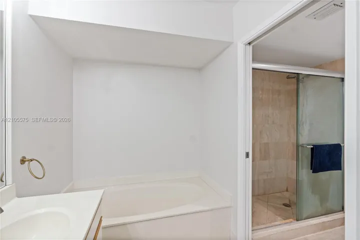Expansive primary bathroom featuring a dual-sink vanity, separate soaking tub, and walk-in shower, offering exceptional space and comfort.