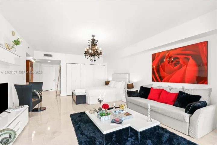Polished tile flooring, built-in wall shelving, a decorative chandelier, and a white paneled door