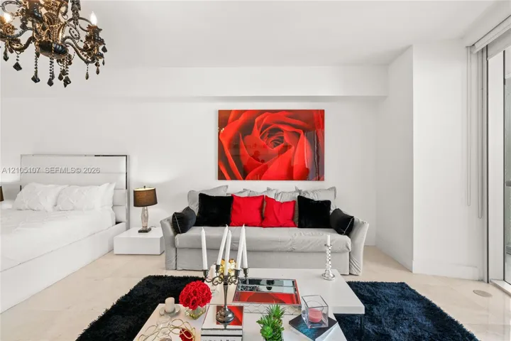 Recessed lighting, black chandelier, white walls, light-toned flooring, and expansive windows