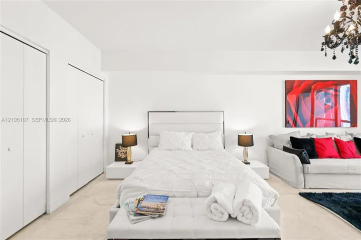 Recessed lighting, light-toned tile flooring, built-in wardrobe, decorative chandelier, and white walls