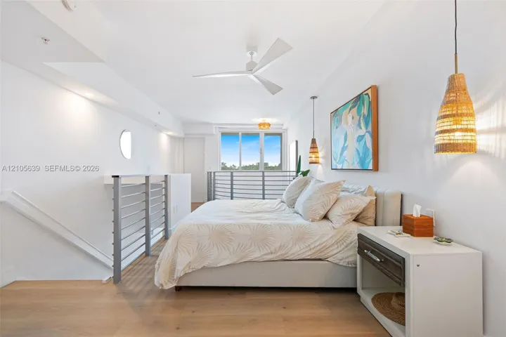 Wood-finish flooring, white three-blade ceiling fan, metal horizontal-bar railings, and woven pendant lighting