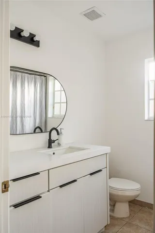 White vanity with black hardware, integrated sink, and matte black faucet