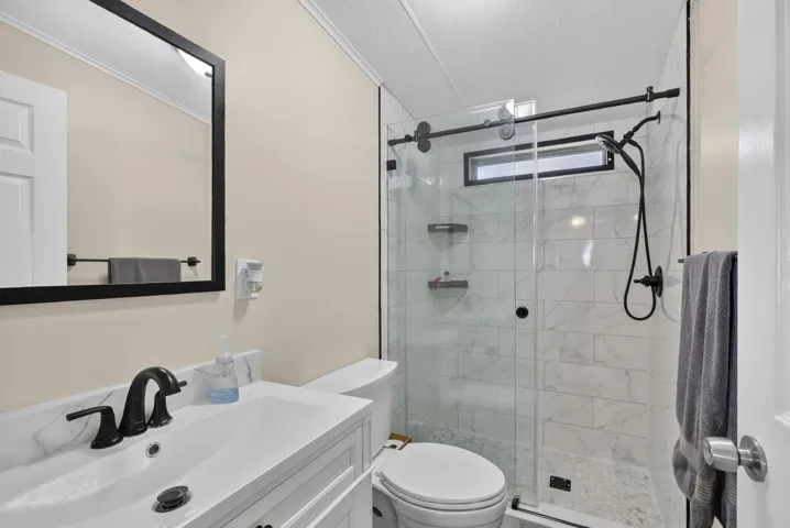 White vanity with an integrated rectangular sink and matte black faucet