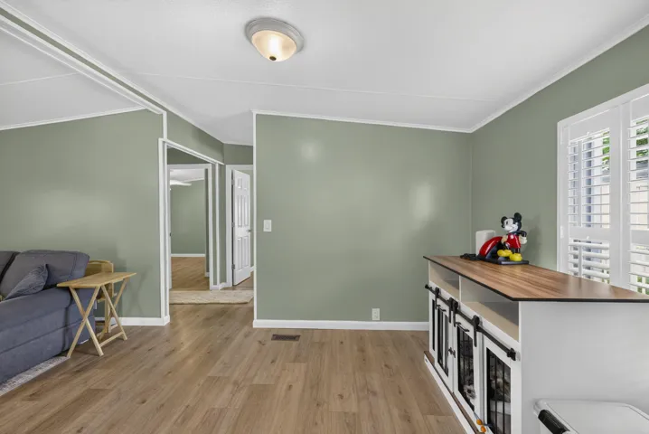 Wood-finish flooring throughout, light green wall finishes, and white ceiling