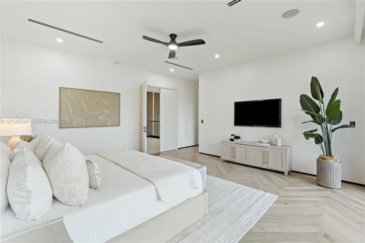 Herringbone-patterned wood-finish flooring, recessed linear lighting, and integrated ceiling speakers