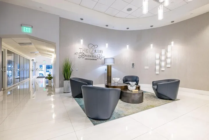 Circular lobby featuring polished tile flooring, recessed cove lighting, accent wall sconces, and a curved architectural design