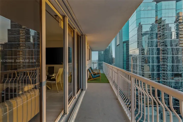 Private balcony with metal railings and sliding glass door entry