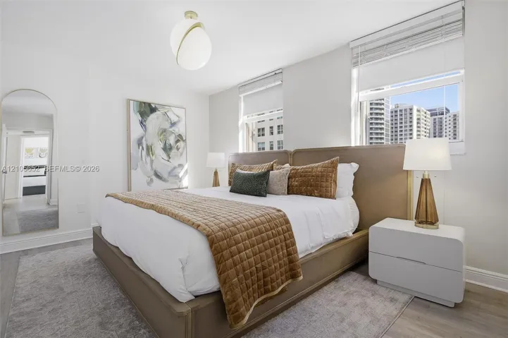 Modern globe-style pendant lighting, wood-finish flooring, and dual oversized windows with urban exposure