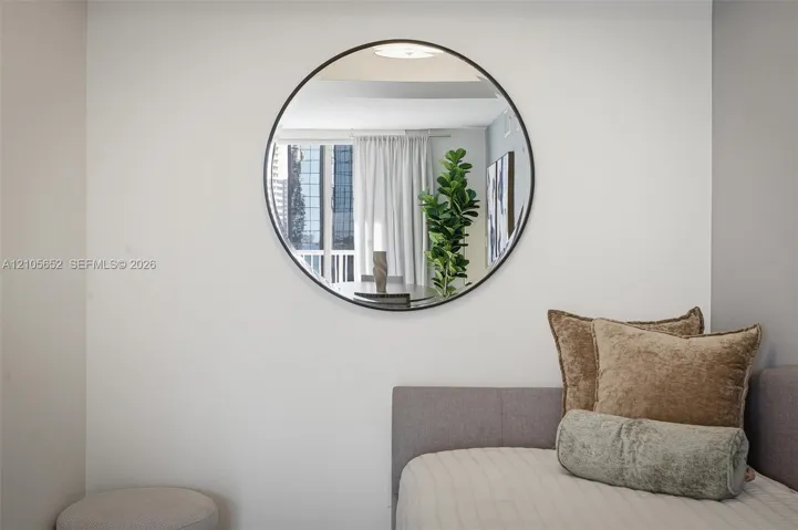 Circular wall-mounted mirror with a thin matte black frame