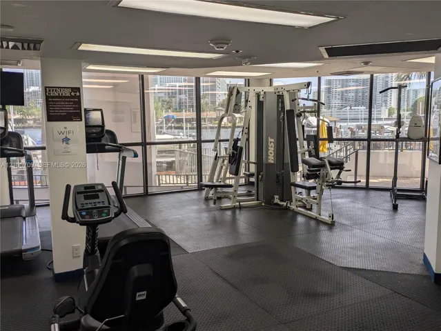 Fitness center featuring floor-to-ceiling windows, rubberized flooring, and recessed ceiling lighting