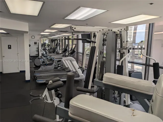 Fitness facility featuring rubberized flooring, expansive floor-to-ceiling windows, and recessed panel lighting
