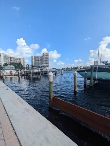 Waterfront bulkhead featuring concrete paved perimeter, deep-water channel access, and multi-slip wooden piling dock system