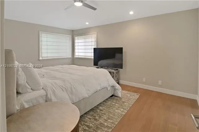 Room featuring wood-finish flooring, recessed lighting, and a ceiling fan