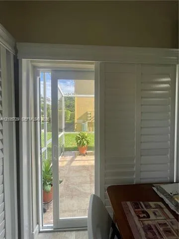 Sliding glass door featuring white plantation shutters and heavy-duty decorative trim framing