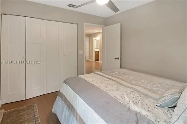 Room featuring neutral-toned walls, wood-finish flooring, a multi-panel closet with integrated doors, and a ceiling-mounted light fixture