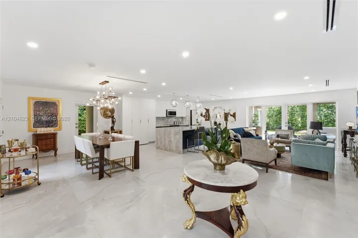 Expansive open-concept space with large format tile flooring, recessed lighting, and a contemporary chandelier
