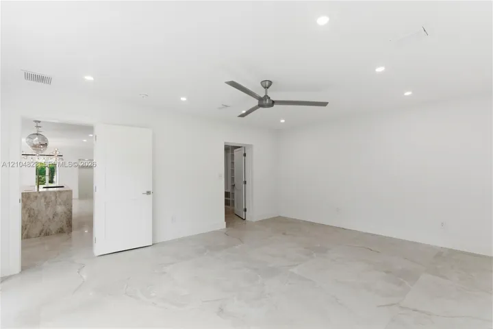 Neutral-toned tile flooring, recessed ceiling lighting, and a modern ceiling fan