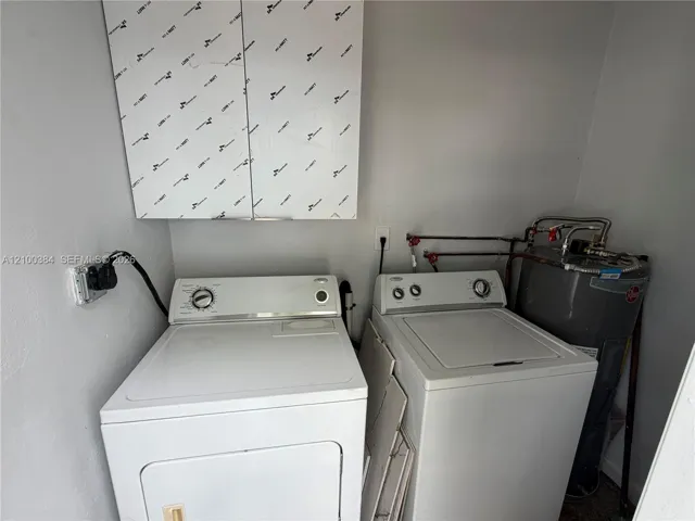 Laundry area featuring upper wall-mounted cabinetry and a standard water heater