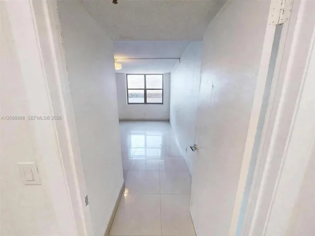 Large-format tile flooring, light-reflective surfaces, and a multi-pane window allowing natural light