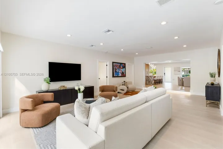 Open-concept interior featuring light wood-finish flooring, neutral wall tones, and recessed lighting