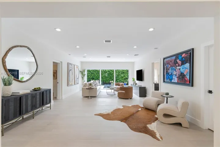 Open-concept interior featuring light-toned flooring, recessed lighting, and expansive sliding glass doors