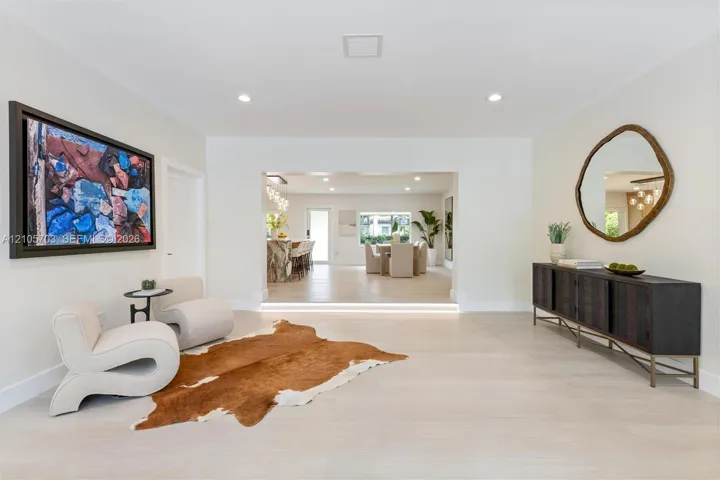 Neutral-toned interior featuring recessed lighting, light-toned wood-finish flooring, and a step-down entryway with integrated riser lighting
